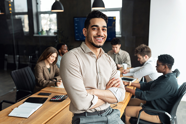 a man smiling at a conference table